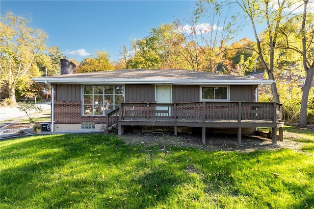 rear view of property featuring a deck and a yard