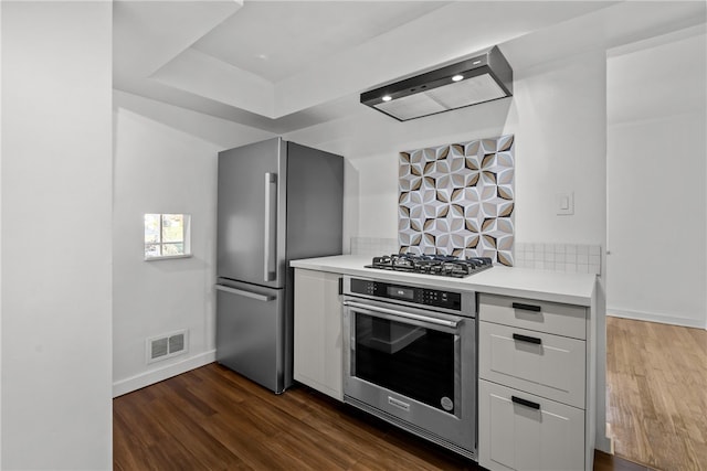 kitchen with stainless steel appliances, dark hardwood / wood-style floors, and extractor fan