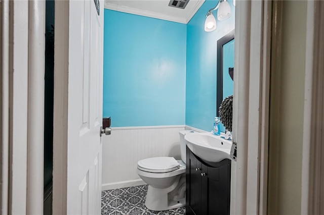 bathroom featuring vanity, ornamental molding, and toilet