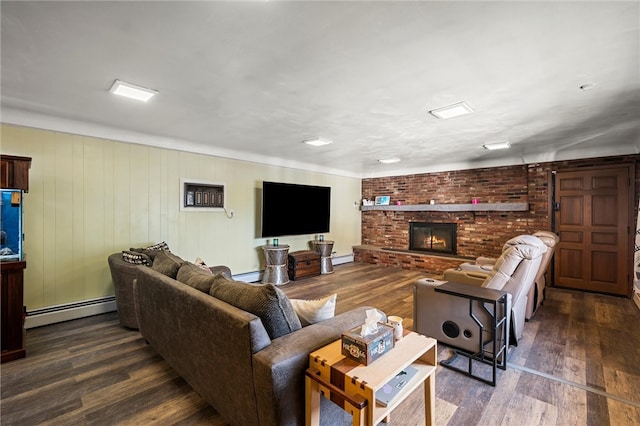 living room with dark wood-type flooring, wood walls, a baseboard heating unit, and a fireplace