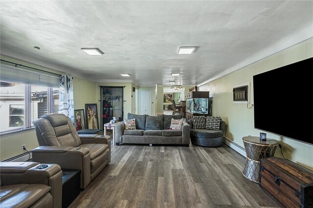 living room featuring wood-type flooring and a baseboard heating unit