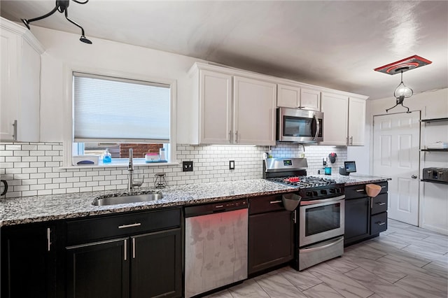 kitchen with backsplash, appliances with stainless steel finishes, sink, and white cabinets