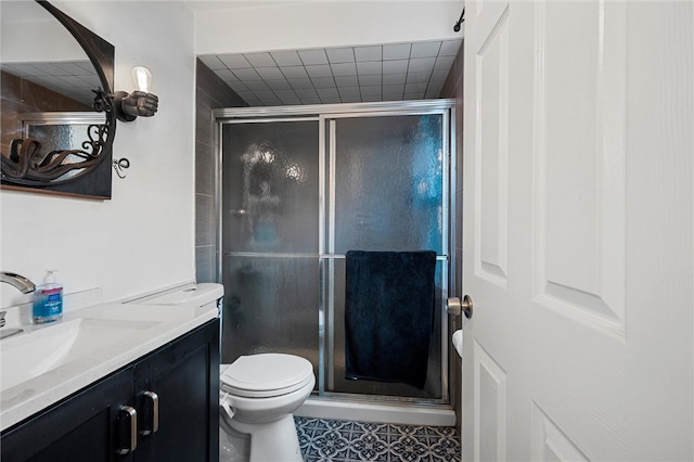 bathroom featuring vanity, toilet, a shower with shower door, and tile patterned flooring