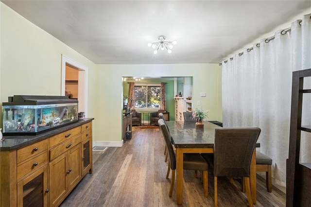 dining area featuring an inviting chandelier and dark wood-type flooring