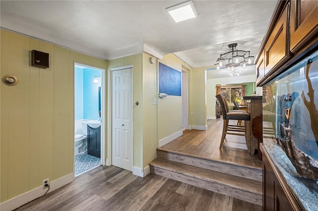 hallway featuring a notable chandelier and dark hardwood / wood-style flooring