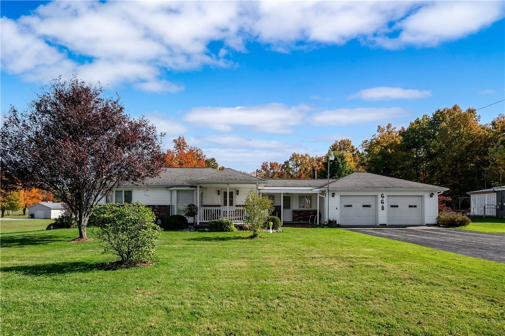 ranch-style house featuring a front lawn, a garage, and covered porch