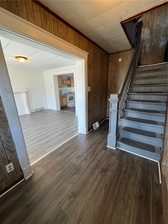 stairs with wooden walls and hardwood / wood-style flooring