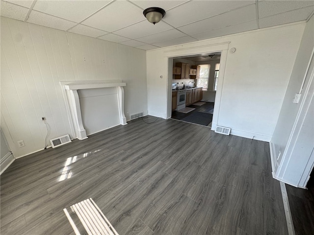 unfurnished living room with sink, a drop ceiling, and dark hardwood / wood-style floors