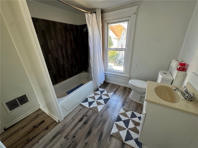 full bathroom with hardwood / wood-style floors, vanity, shower / tub combo, and toilet