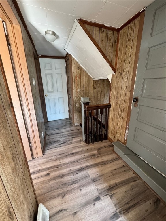 interior space with wood walls and light hardwood / wood-style flooring