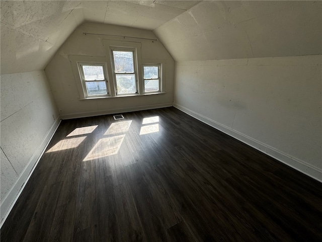 additional living space with lofted ceiling and dark hardwood / wood-style flooring