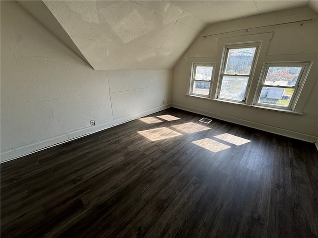 additional living space with lofted ceiling and dark wood-type flooring