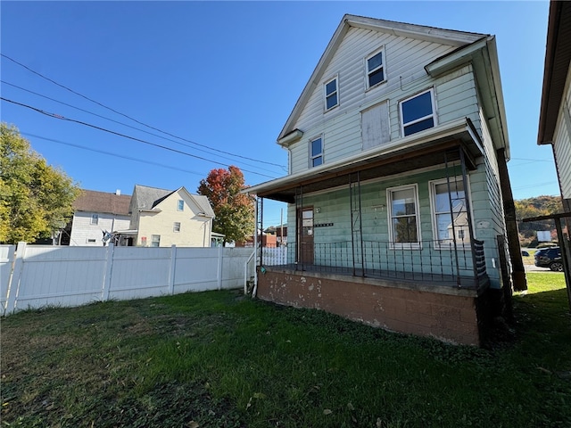 rear view of property with a yard and a porch