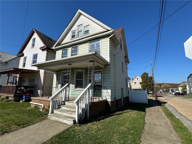 view of front property featuring covered porch and a front yard