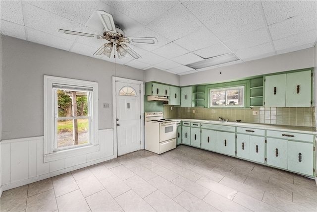 kitchen featuring decorative backsplash, white electric range, sink, green cabinetry, and ceiling fan