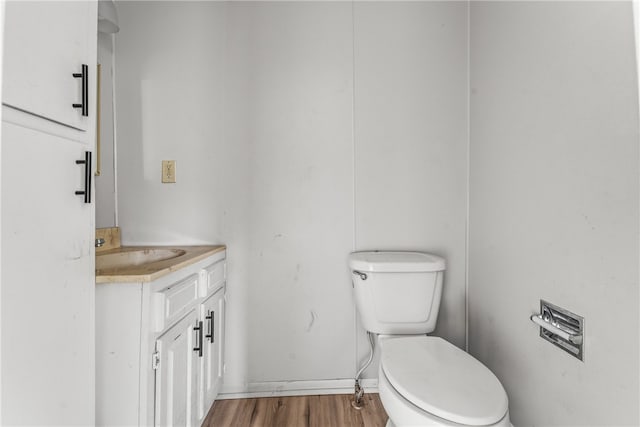 bathroom with vanity, toilet, and hardwood / wood-style floors