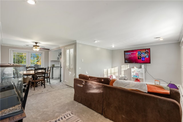 carpeted living room with ornamental molding and ceiling fan