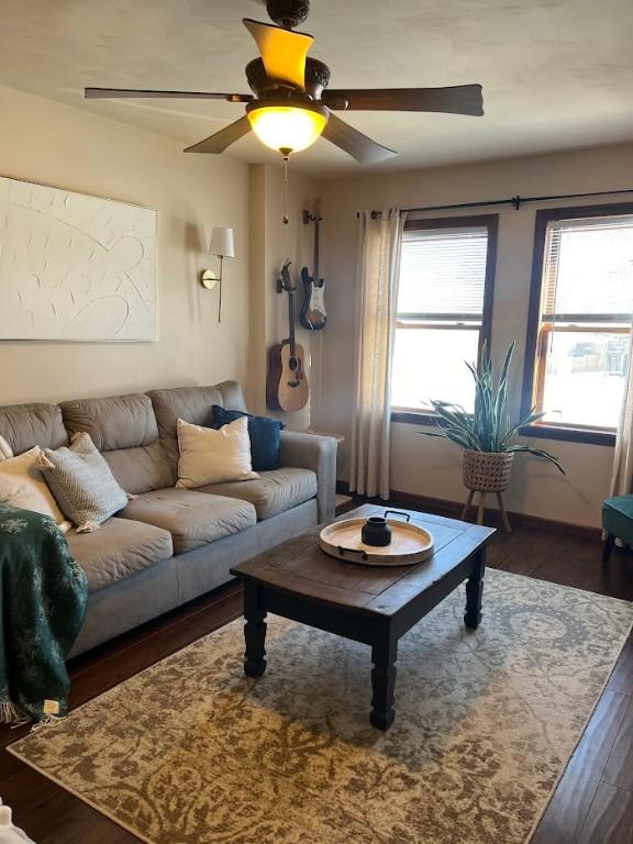 living room featuring ceiling fan, a wealth of natural light, and dark hardwood / wood-style flooring