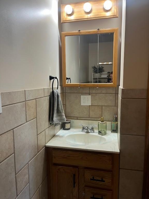 bathroom featuring vanity and tile walls