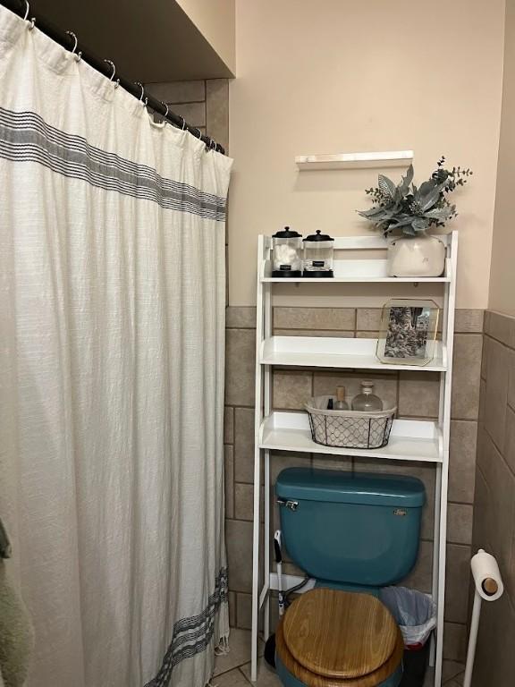 bathroom with tile walls and tile patterned flooring