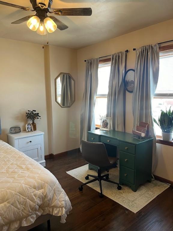 bedroom featuring ceiling fan, dark hardwood / wood-style floors, and multiple windows