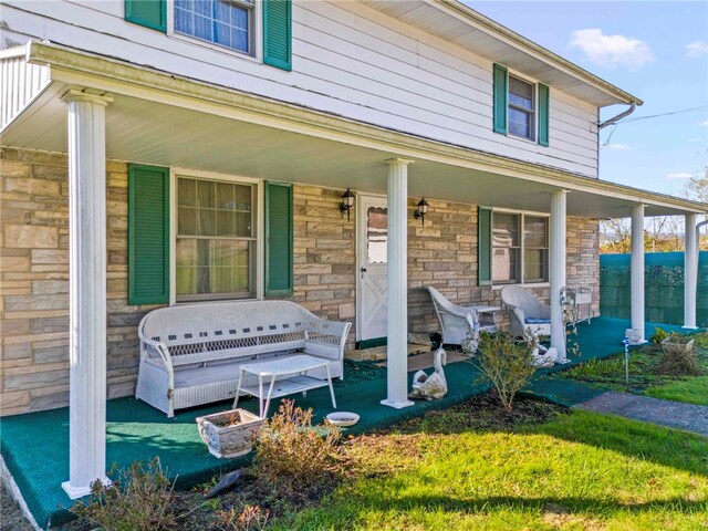 doorway to property featuring a yard and covered porch