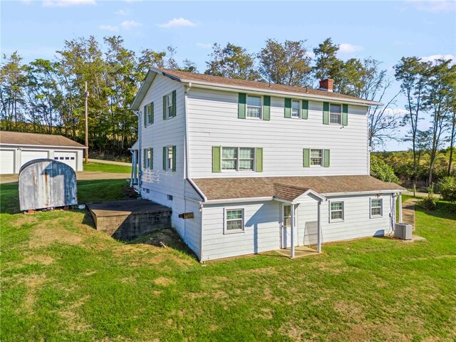 back of property with a shed, central air condition unit, and a lawn