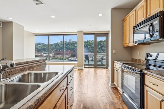 kitchen with light hardwood / wood-style floors, black appliances, sink, and light brown cabinets