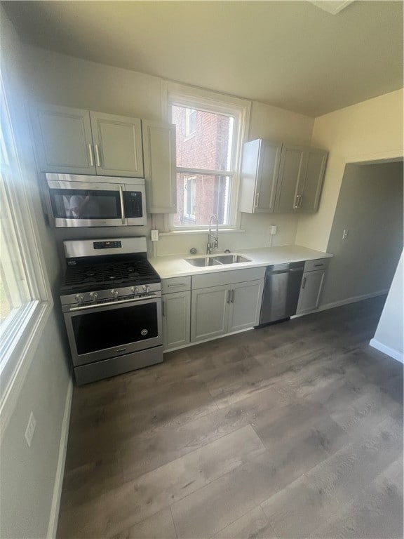 kitchen with stainless steel appliances, sink, and light wood-type flooring