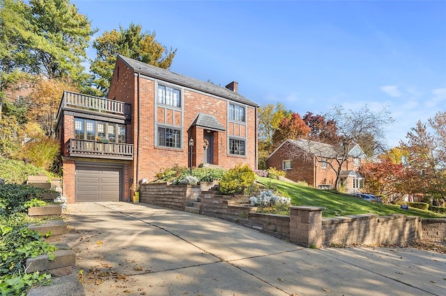 view of property featuring a front yard, a garage, and a balcony