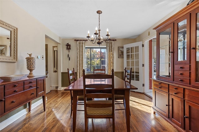 dining space featuring a notable chandelier and light wood-type flooring