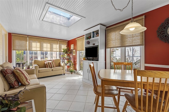 dining room with light tile patterned floors, a healthy amount of sunlight, and a skylight