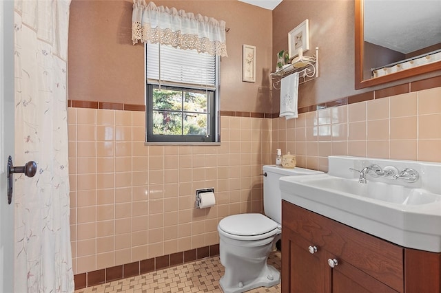 bathroom featuring toilet, tile patterned flooring, a shower with curtain, vanity, and tile walls