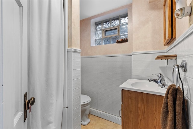 bathroom with tile walls, vanity, toilet, and tile patterned flooring