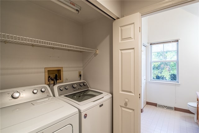 laundry room featuring washing machine and dryer and light tile patterned floors