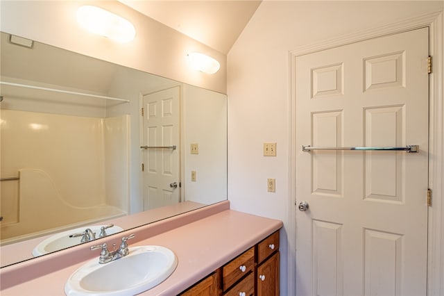 bathroom with vanity, a shower, and vaulted ceiling