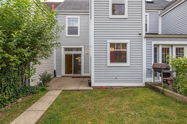 rear view of property featuring a patio and a lawn