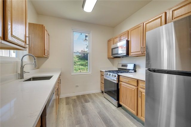 kitchen with sink, appliances with stainless steel finishes, and light wood-type flooring