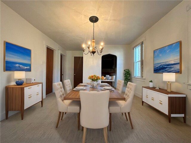 dining space with carpet flooring and an inviting chandelier