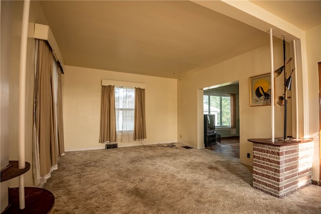 living room with dark colored carpet and a wealth of natural light