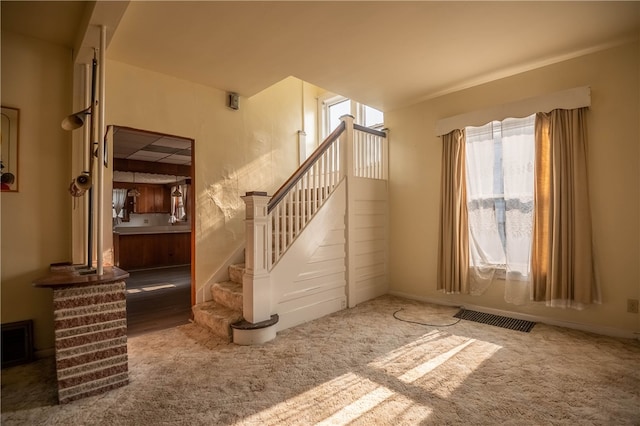 staircase featuring carpet flooring and a wealth of natural light