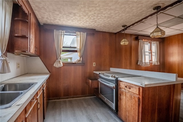 kitchen with hardwood / wood-style floors, decorative light fixtures, stainless steel electric range oven, and wooden walls