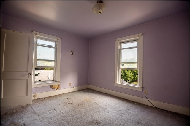 empty room with carpet floors and a wealth of natural light