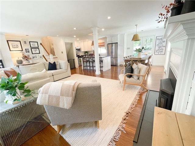 living room with decorative columns and light hardwood / wood-style flooring