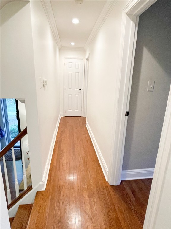 corridor with crown molding and hardwood / wood-style floors