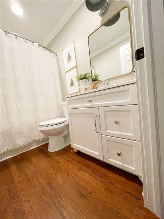 bathroom with vanity, crown molding, hardwood / wood-style floors, and toilet