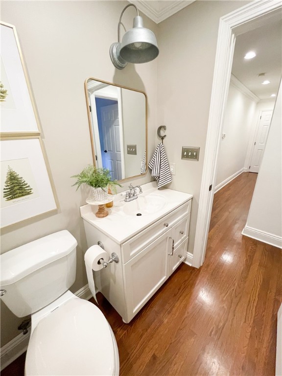 bathroom featuring vanity, crown molding, and toilet