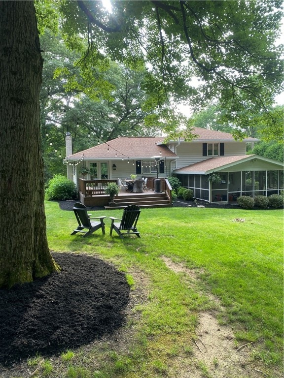 view of yard featuring a wooden deck and a sunroom