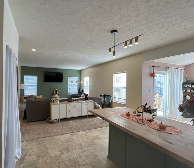 kitchen with a healthy amount of sunlight, a textured ceiling, and track lighting