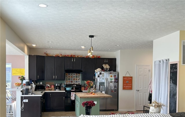 kitchen with hanging light fixtures, stainless steel fridge, a textured ceiling, black range with electric cooktop, and butcher block counters